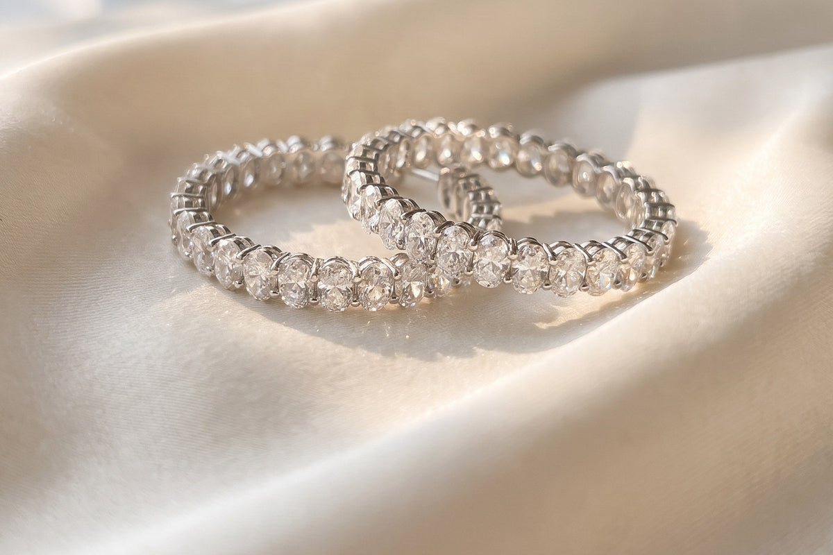 Two lab grown diamond eternity bands resting on cream silk in soft window light, Draco Diamond