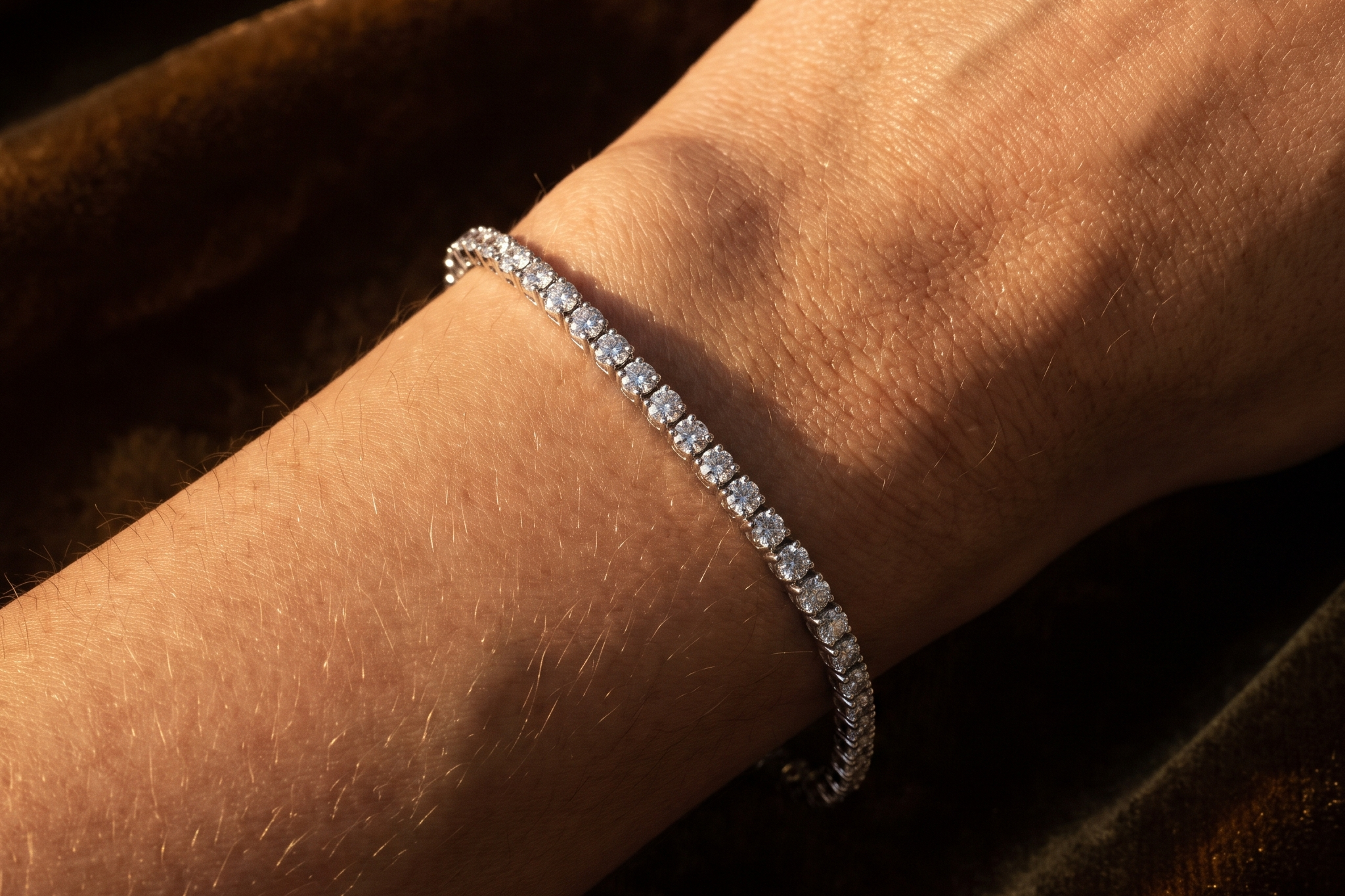 Lab diamond tennis bracelet draped over a bare wrist on a warm dark background, Draco Diamond bracelet comparison