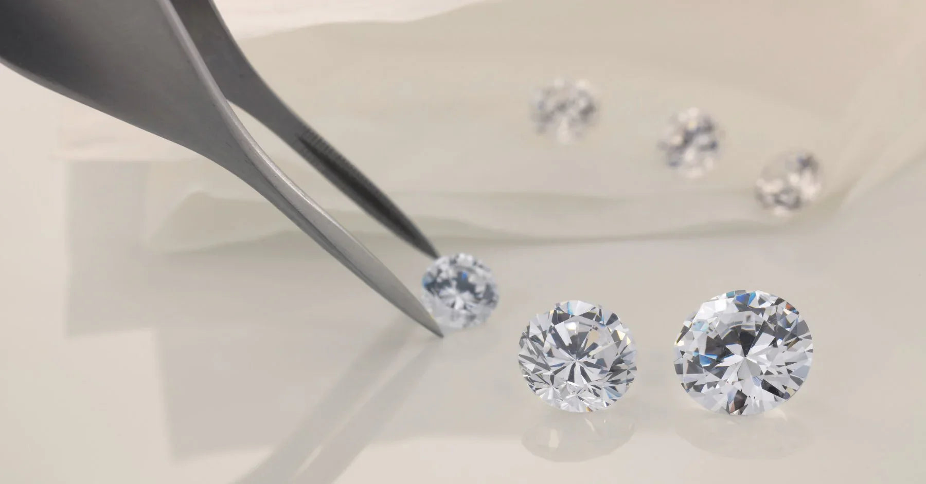 Loose lab grown diamonds held in tweezers, real crystallized carbon, IGI certified