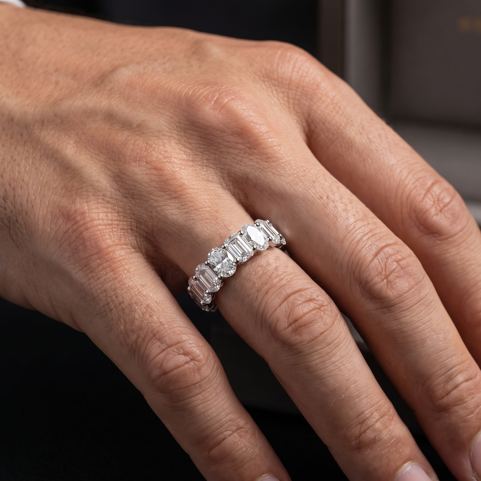 4.9ct oval and emerald cut half eternity lab grown diamond ring worn on a masculine mans hand