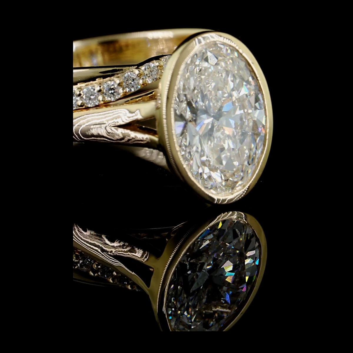 3ct oval bezel lab grown diamond bridal set, 14k yellow gold, real video still on black, oval centre in bezel with pave split shank