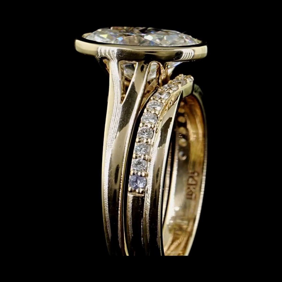 3ct oval bezel lab grown diamond bridal set, 14k yellow gold, real video still on black, split shank side profile with matching pave band