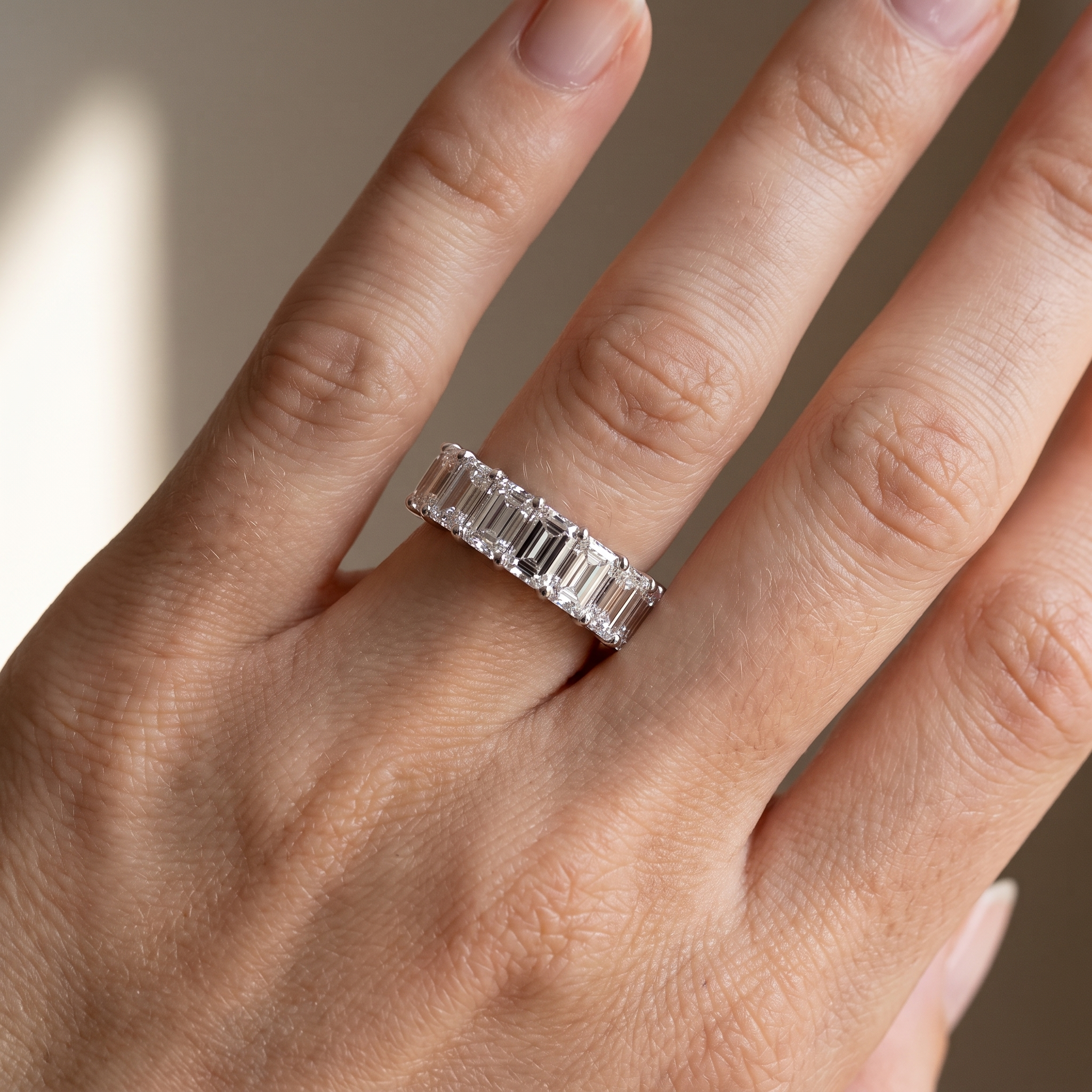 8ct emerald cut lab diamond eternity band worn on hand, close up