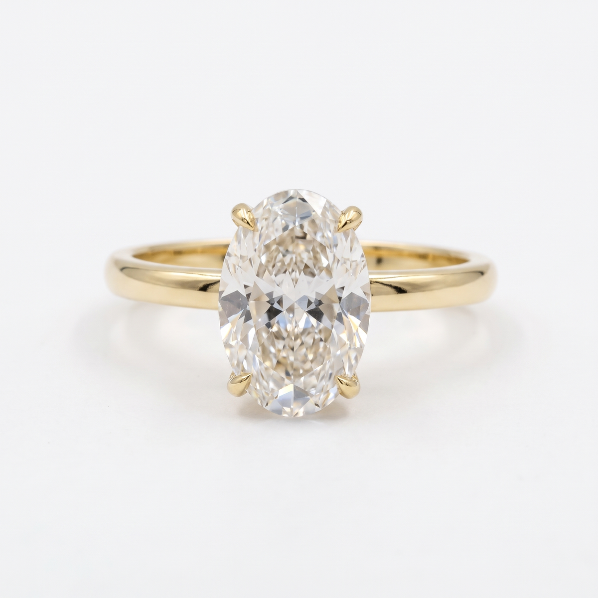 3ct oval hidden halo lab grown diamond engagement ring, 14k yellow gold, studio front view on white