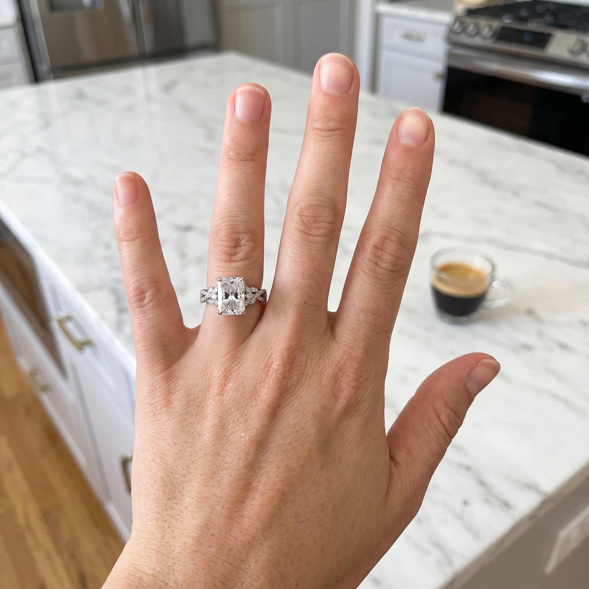 customer showing 3ct radiant twisted vine lab diamond engagement ring, luxury kitchen