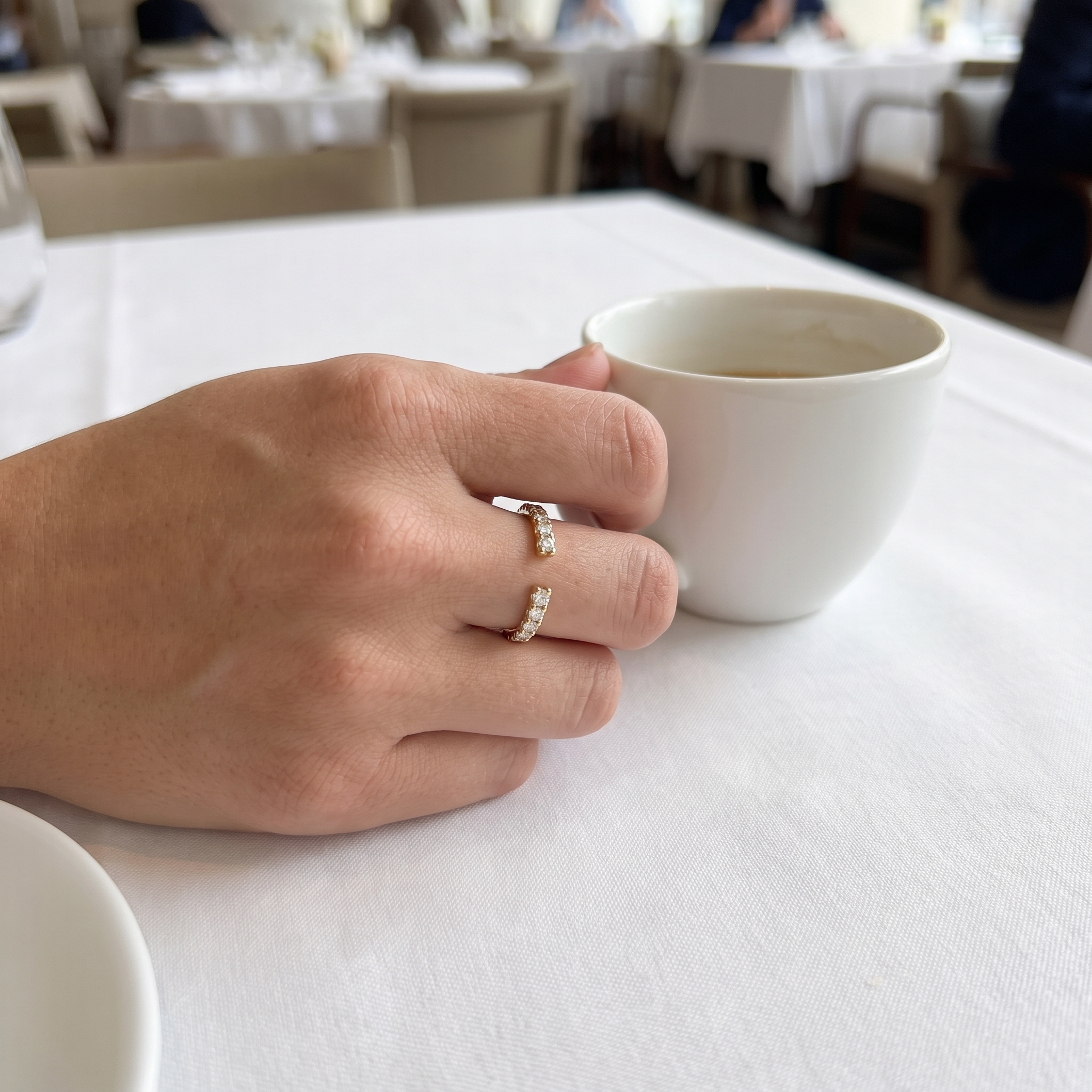 customer wearing open pave lab diamond cuff ring at cafe