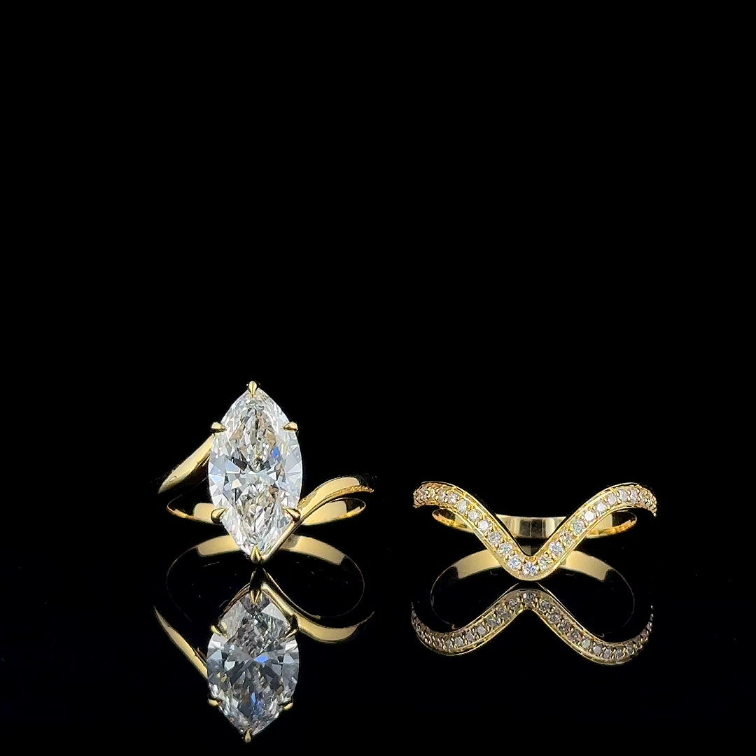 3ct marquise bypass ring and chevron band side by side, yellow gold, on black