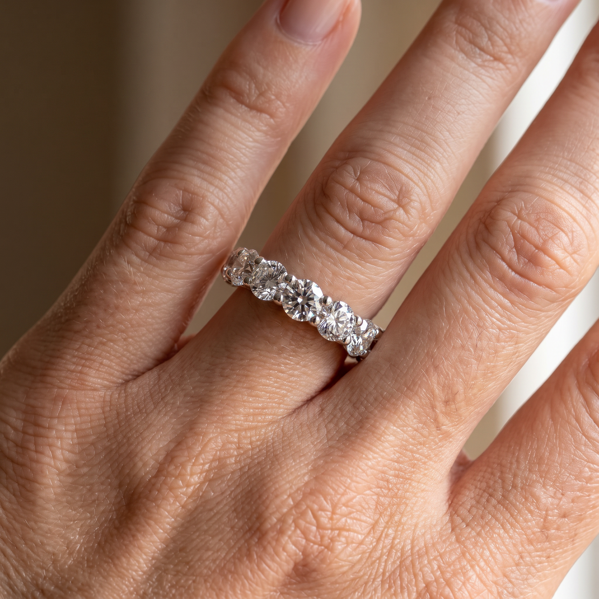 8ct round lab diamond eternity band worn on hand, close up