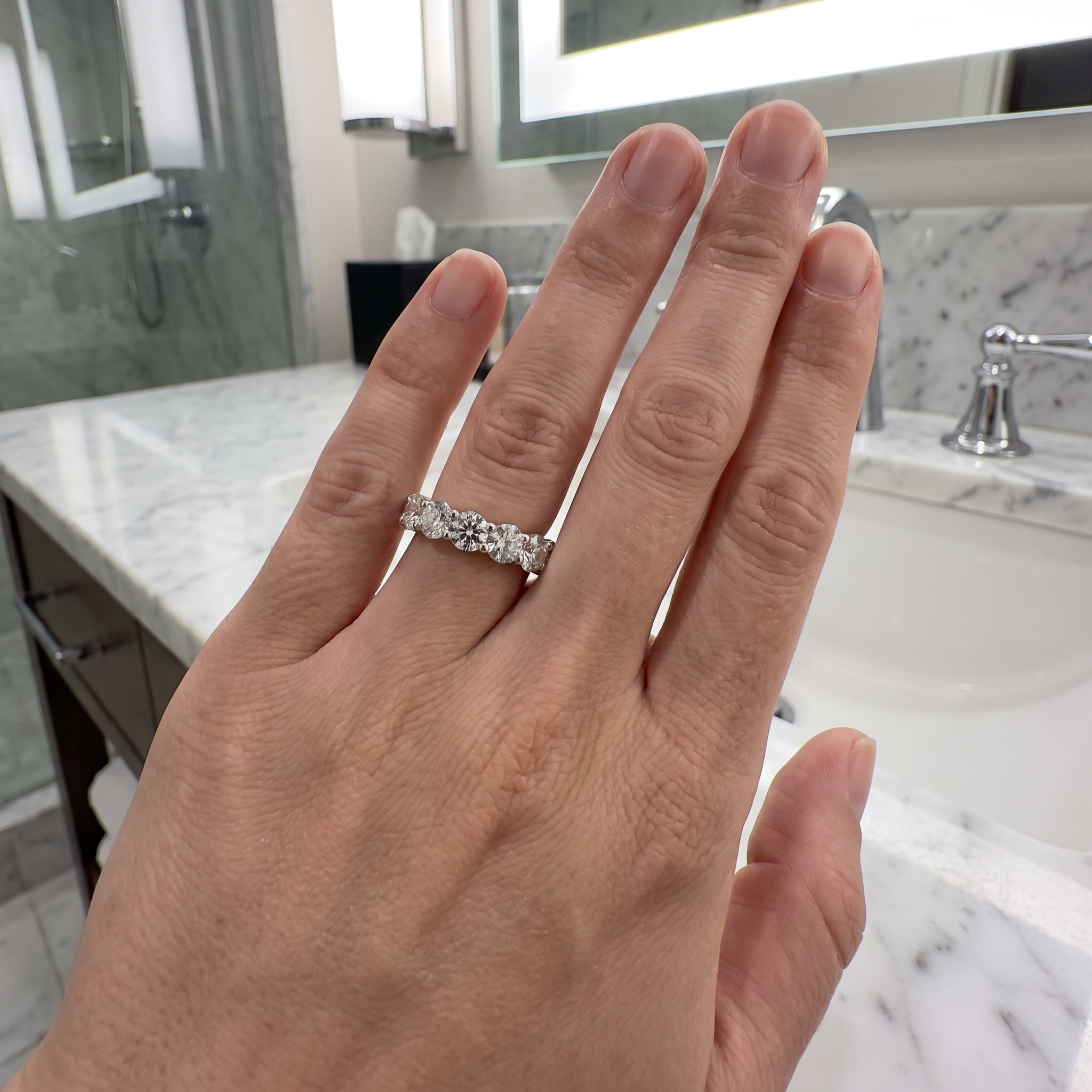 customer wearing 8ct round lab grown diamond eternity band, marble vanity