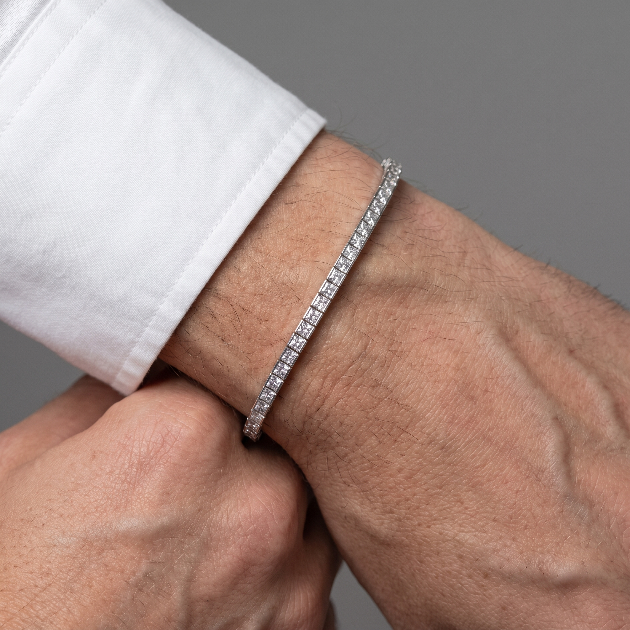 7ctw bezel set princess cut lab grown diamond tennis bracelet worn on a mans wrist below a shirt cuff