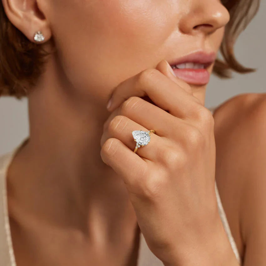 Pear cut lab diamond engagement ring worn on the hand in yellow gold, IGI certified, Draco Diamond