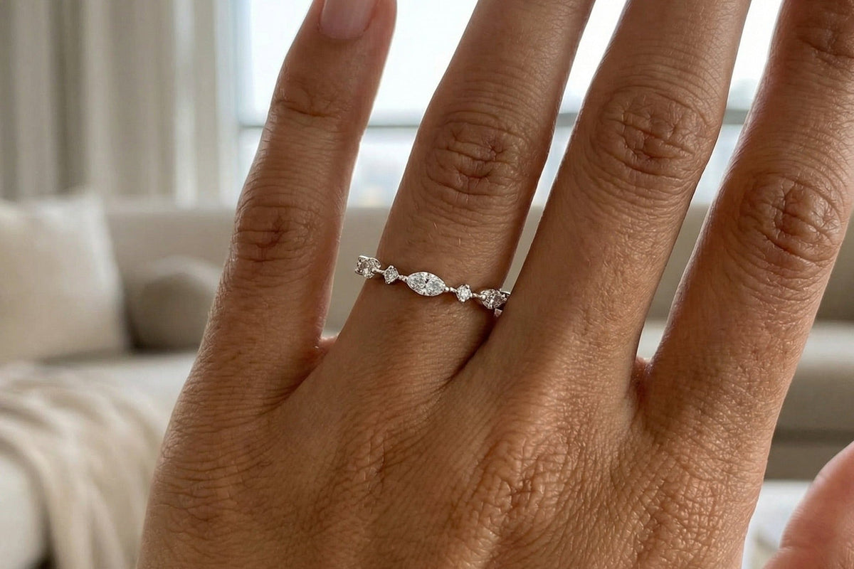 Delicate marquise and round lab grown diamond band worn on a hand in bright window light, entry level scale, Draco Diamond