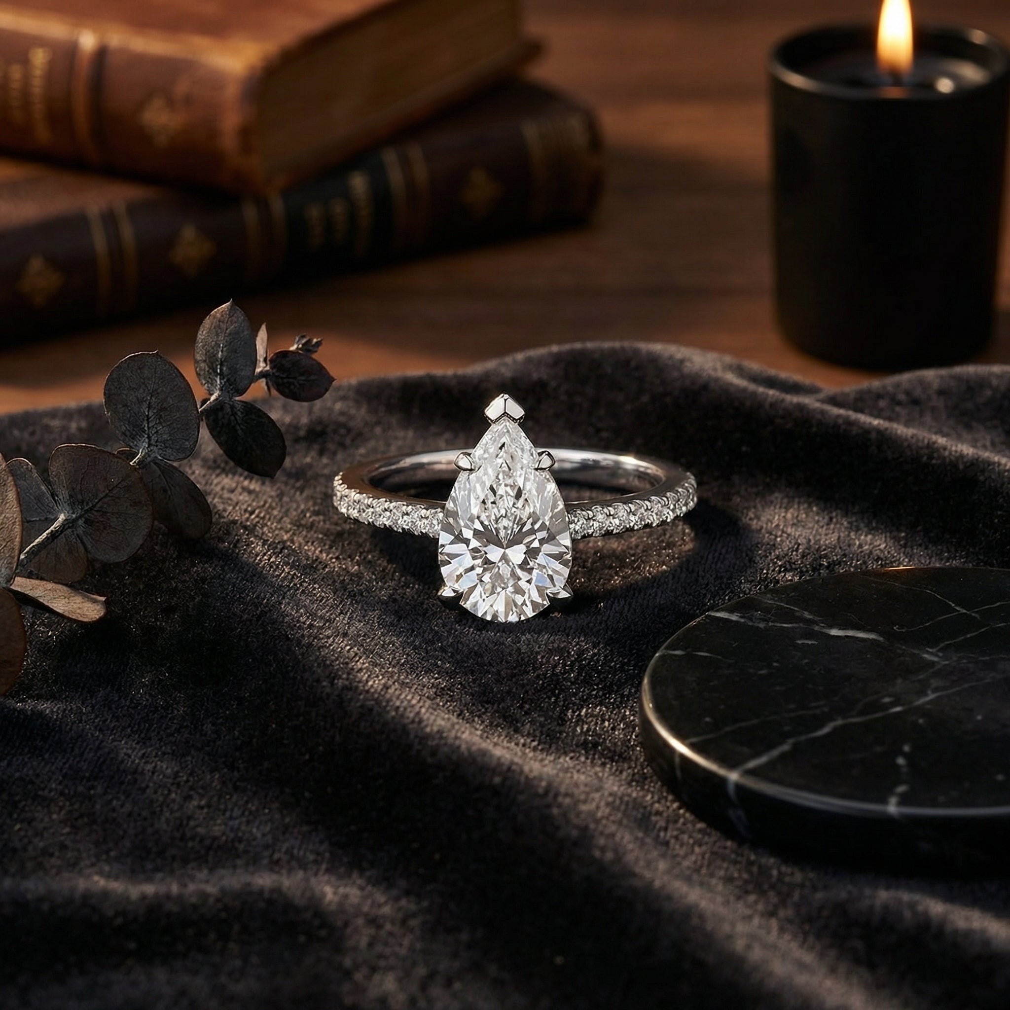 2ct pear cut lab diamond engagement ring resting on dark velvet, viewed at the normal distance where eye clean clarity is judged
