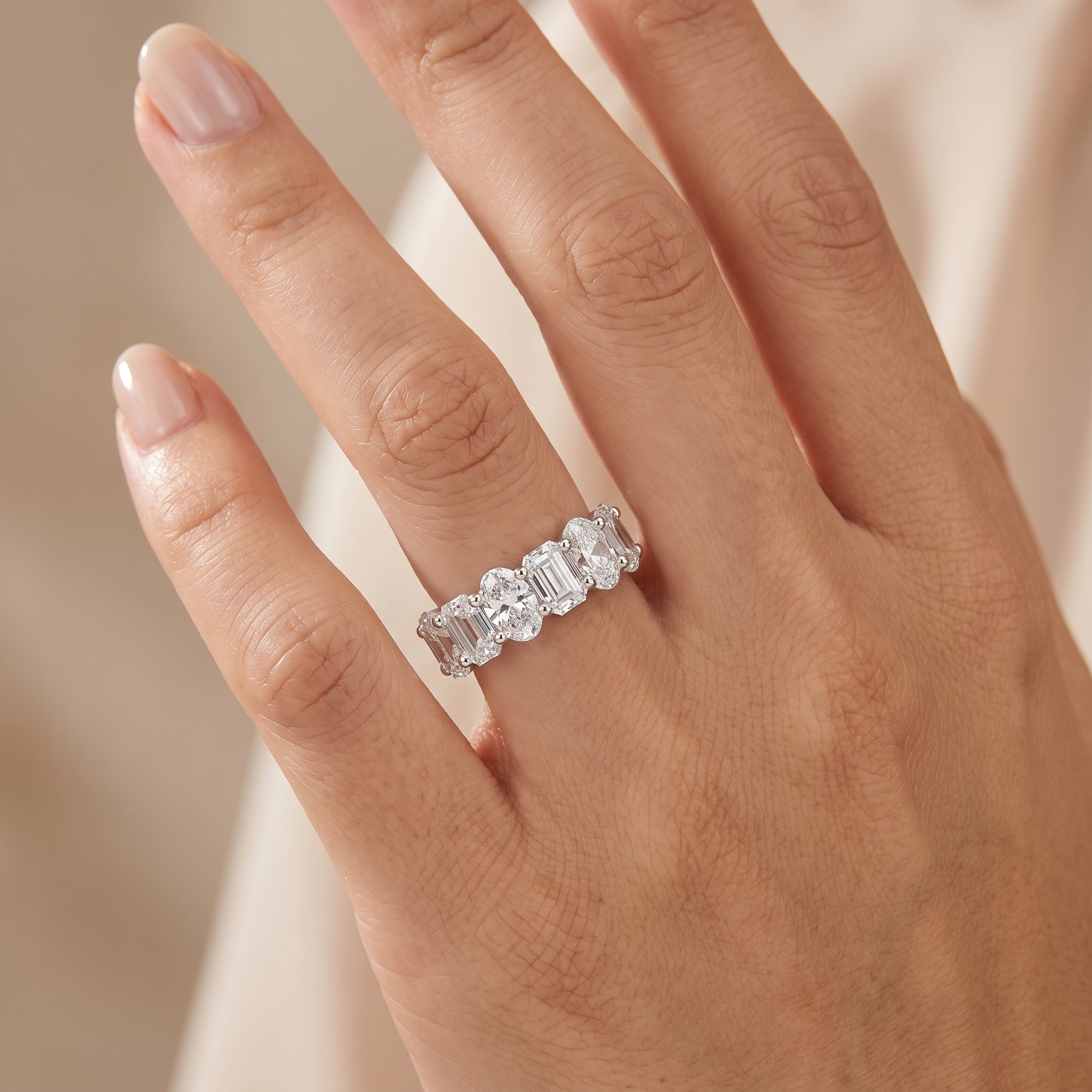 4.9ct oval and emerald cut half eternity lab grown diamond ring worn true to size on a womans hand
