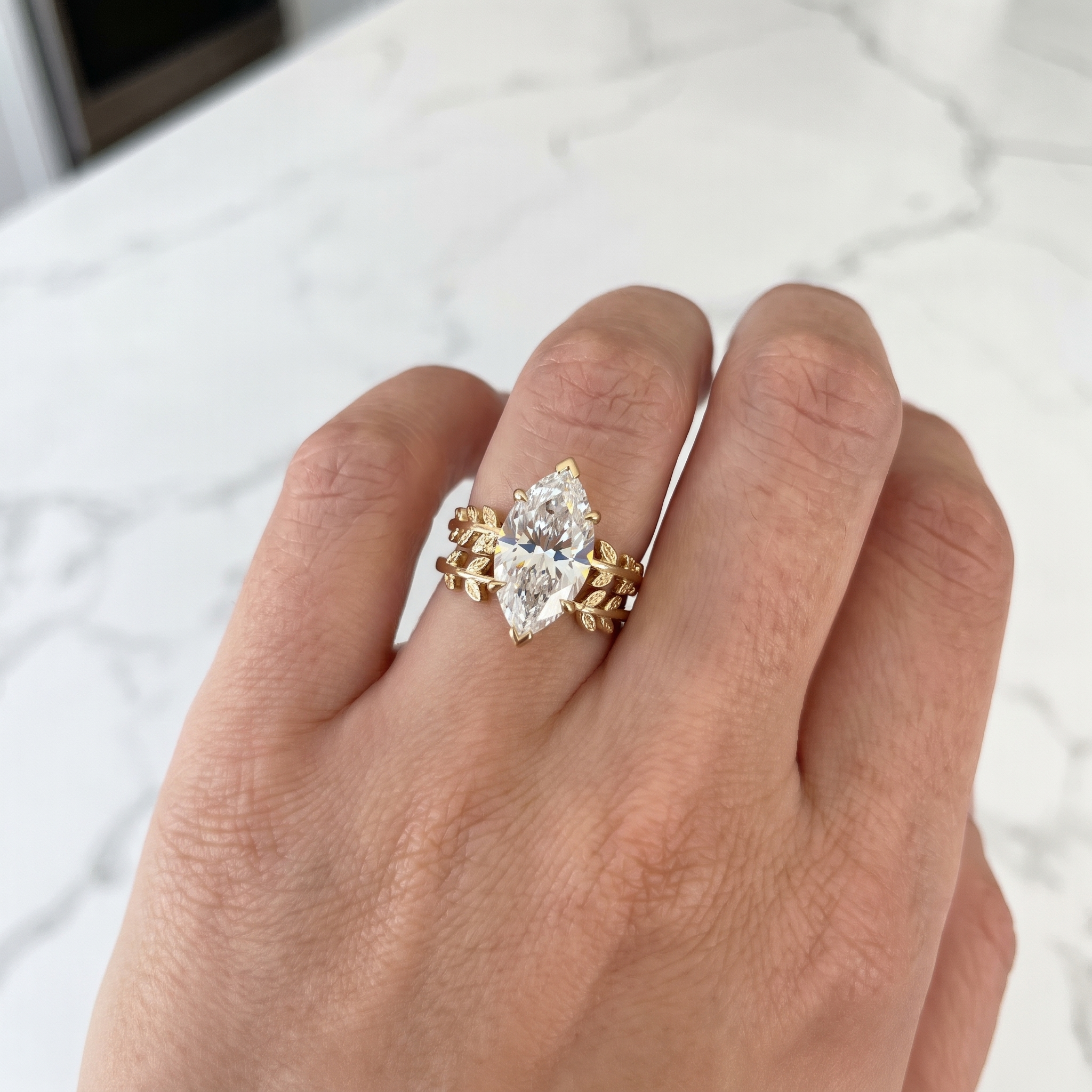 customer showing marquise leaf lab diamond bridal set, luxury kitchen