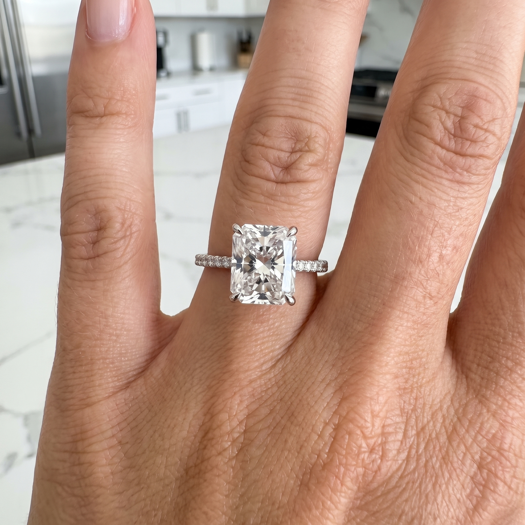customer showing 5ct radiant lab diamond engagement ring, luxury kitchen