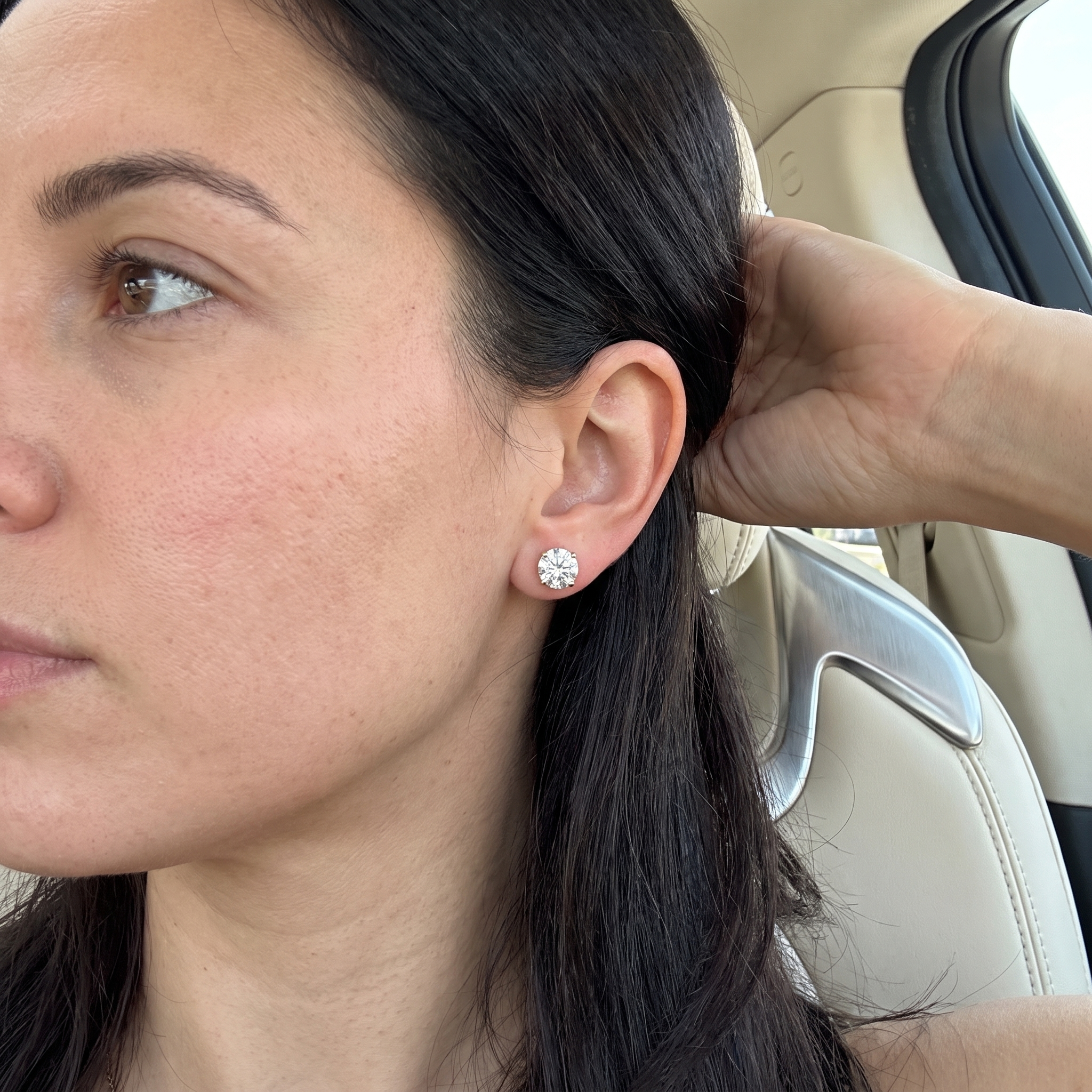 customer showing 4ctw round lab diamond stud earring, car interior