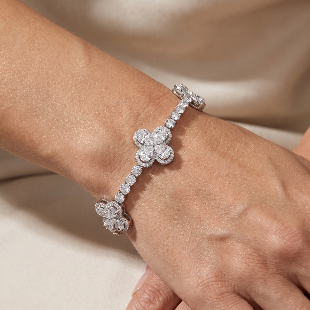 13ct pear clover lab grown diamond tennis bracelet worn on a womans wrist, clovers spaced