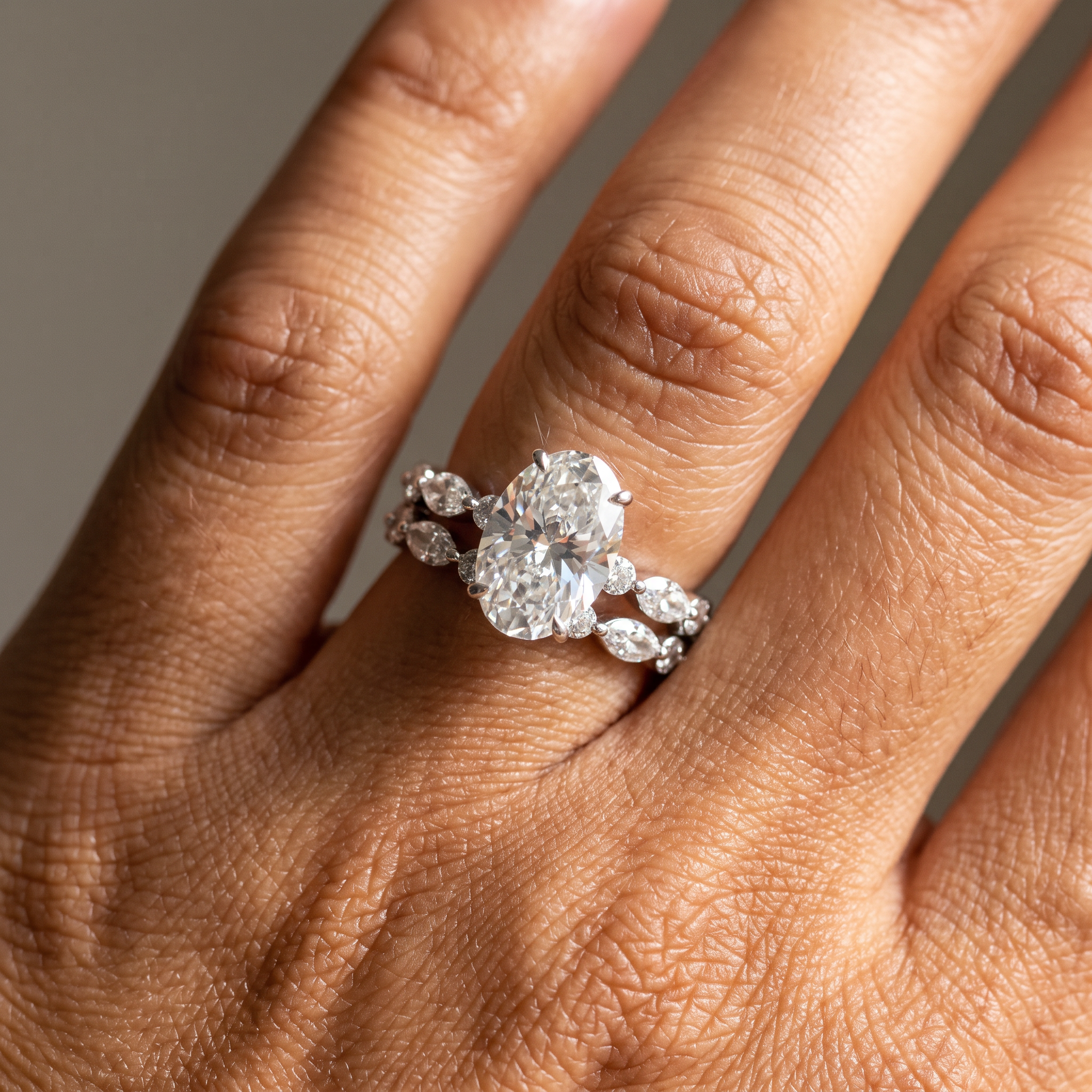 3ct oval white gold lab grown diamond bridal set worn on the hand, close-up of ring stacked with band