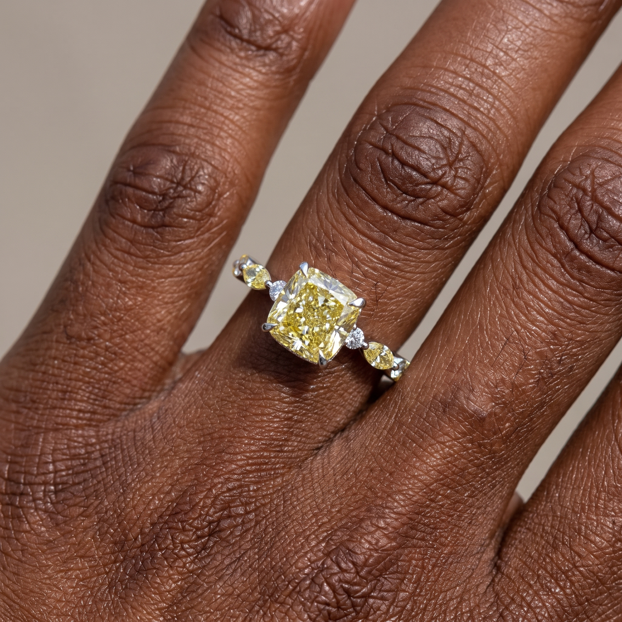 4.3ctw fancy yellow cushion lab grown diamond engagement ring worn on the hand, three quarter view