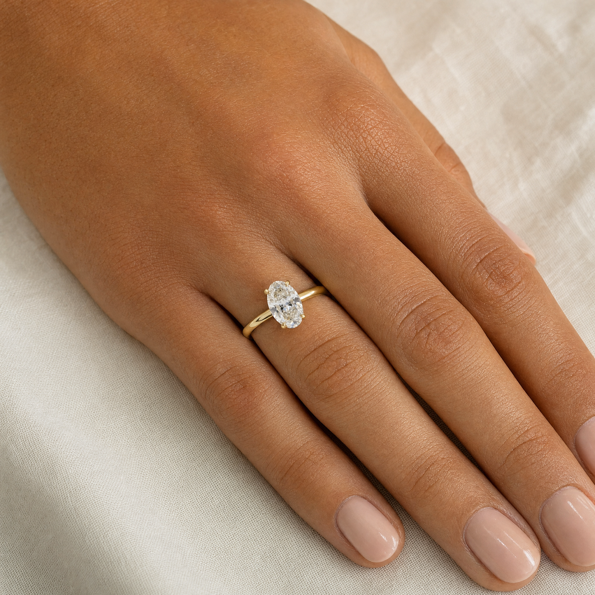 3ct oval hidden halo lab grown diamond engagement ring worn on the hand, 14k yellow gold, true to size