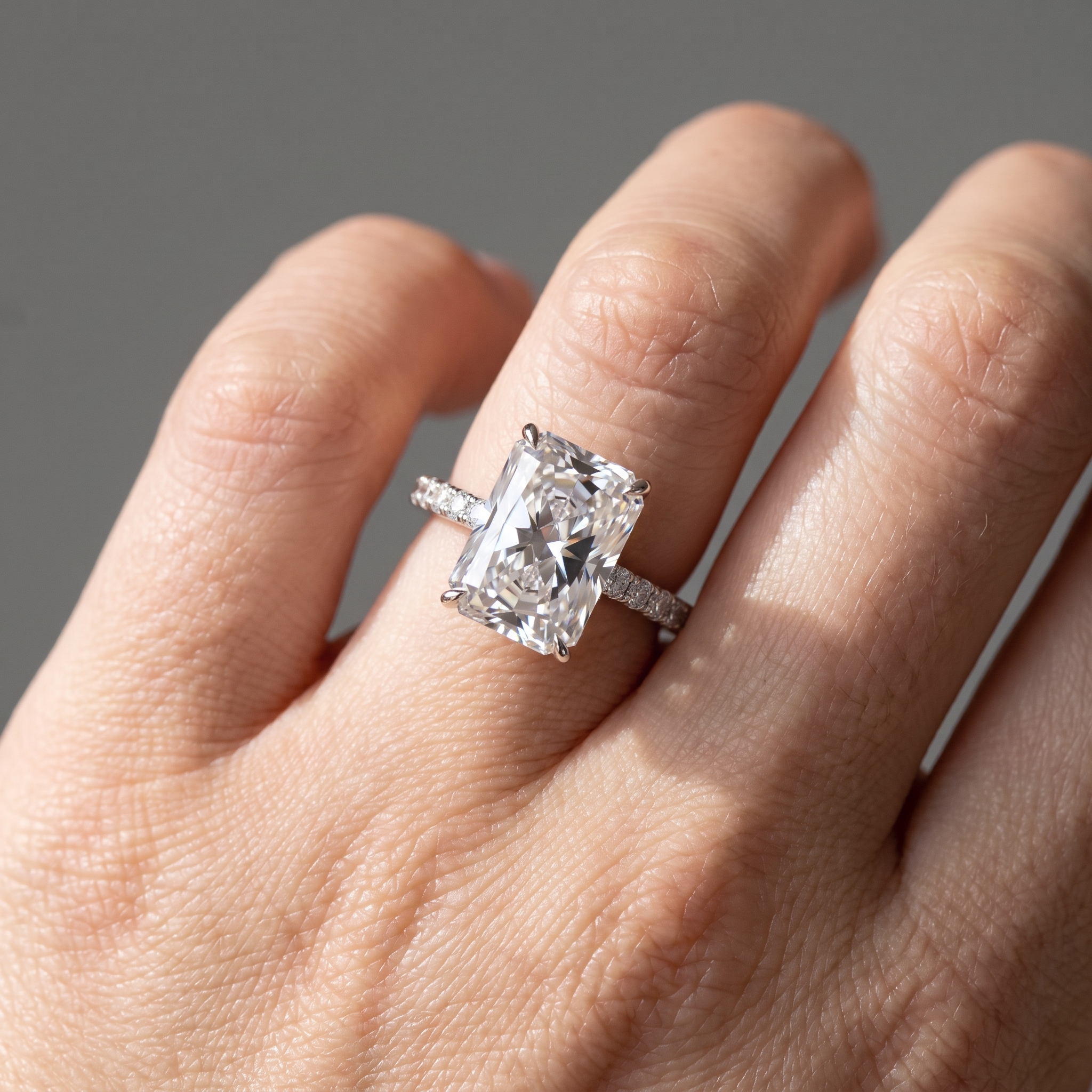5ct radiant cut lab grown diamond engagement ring worn on the hand, front view