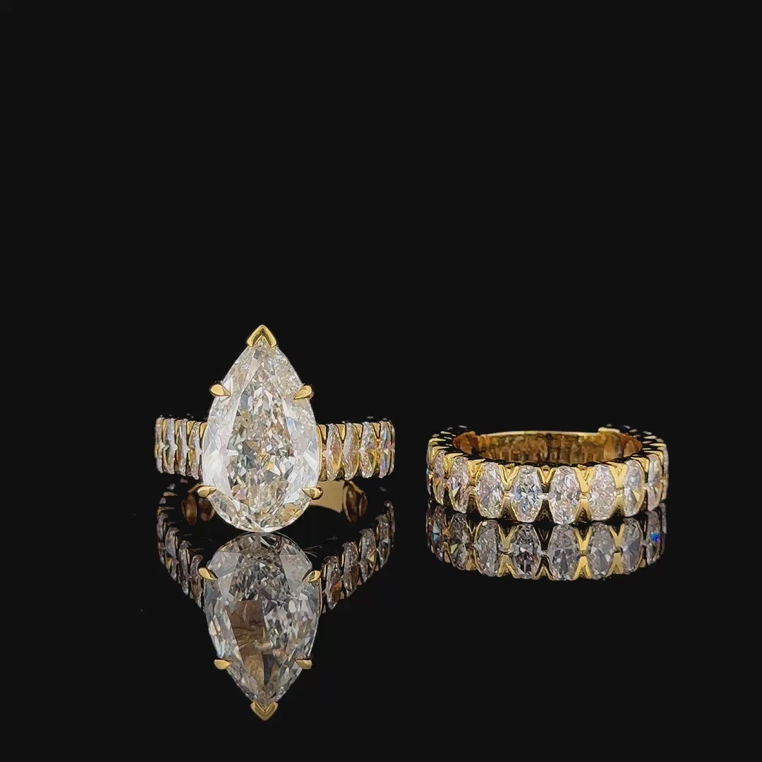 pear lab diamond bridal set, ring and matching oval eternity band on turntable