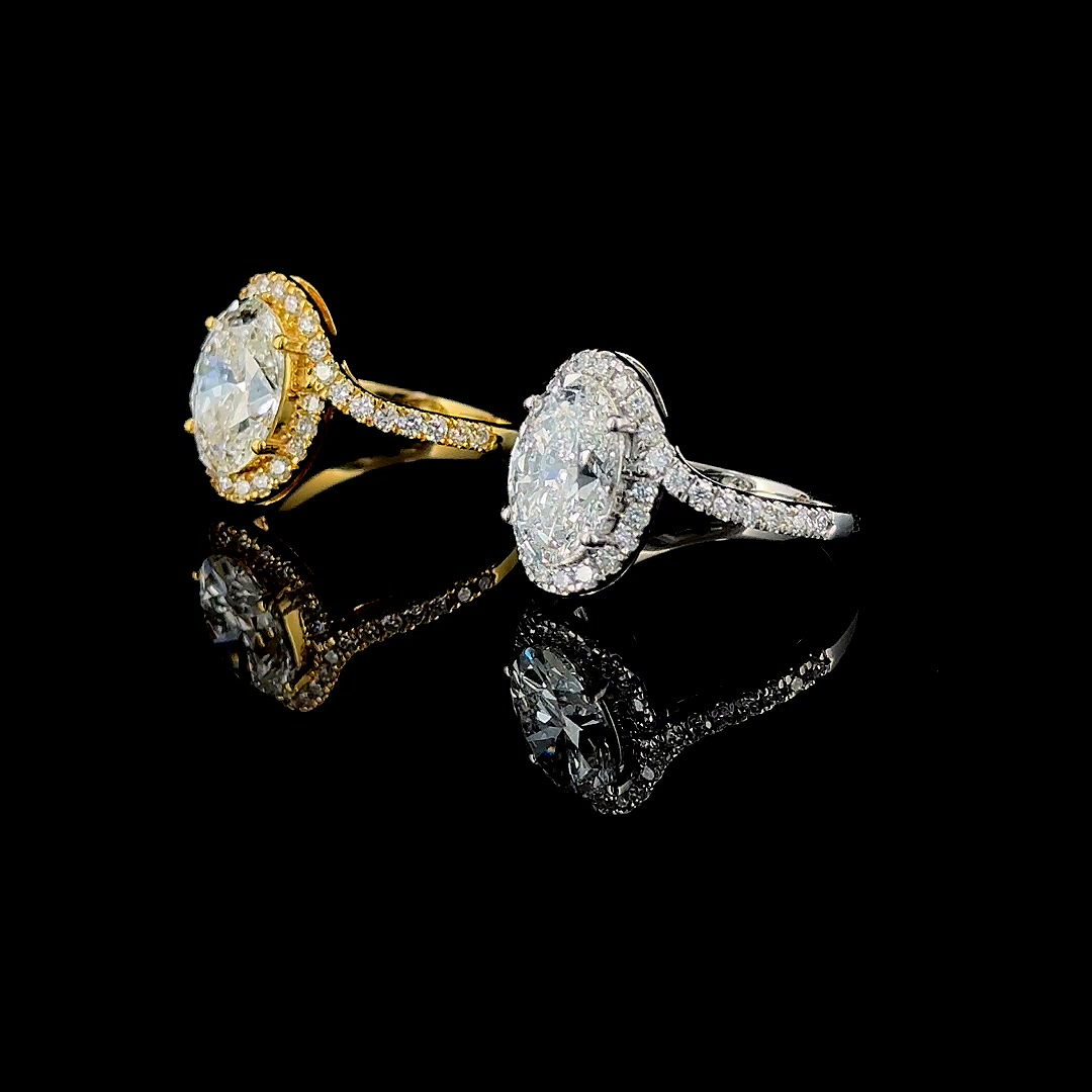 3ct oval halo lab grown diamond engagement ring shown in yellow gold and white gold side by side, on black