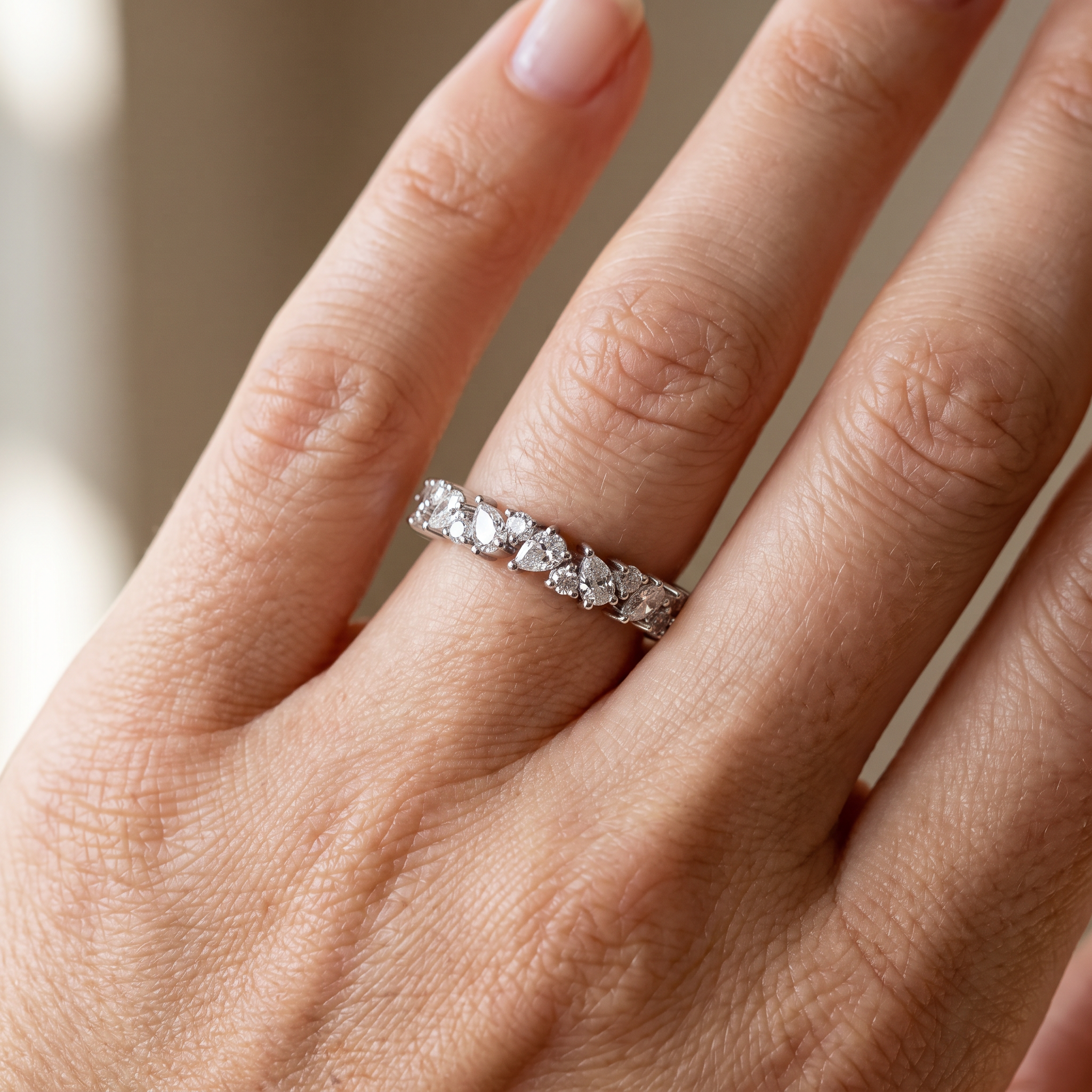 2ct pear and round cluster lab diamond band worn on hand, close up