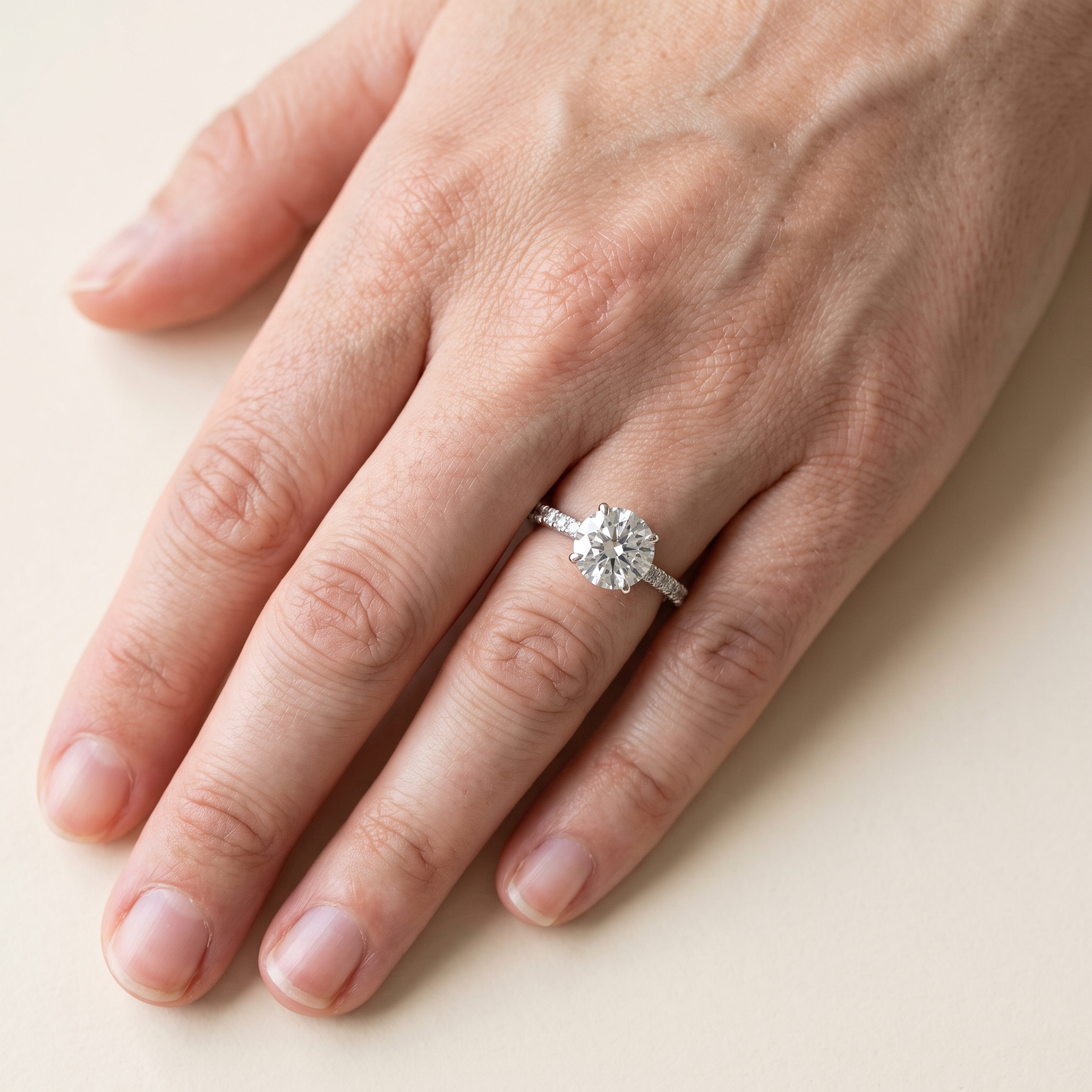 2ct round brilliant lab diamond engagement ring worn on the hand, seen from above, 8.1mm centre stone with pave shoulders