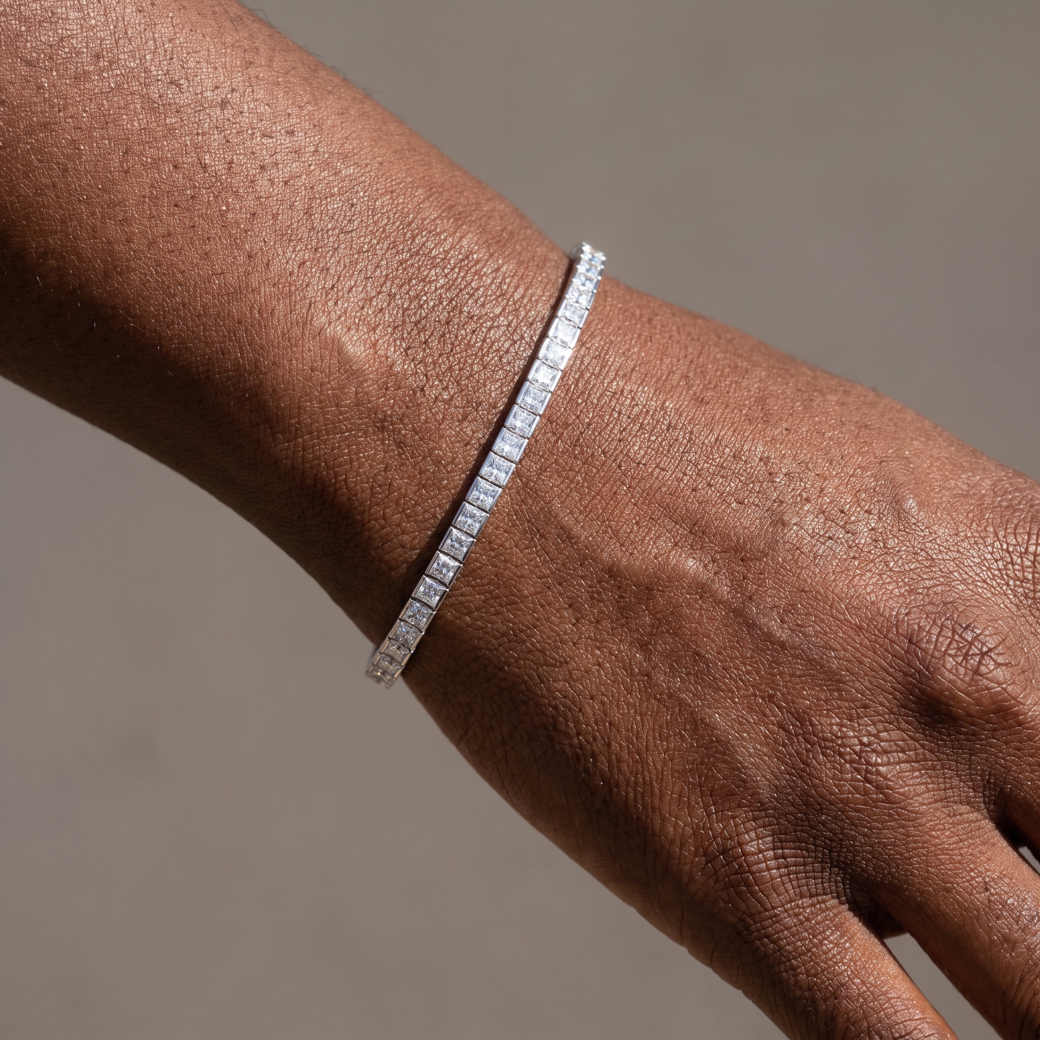 7ctw bezel set princess cut lab grown diamond tennis bracelet worn on the wrist, three quarter view